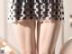 A close up of a woman's legs wearing a skirt.