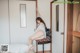 A woman sitting on a chair in a bedroom.