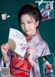 A woman in a kimono holding a fan in her hand.