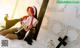 A woman dressed as a nun sitting on a bed holding a cross.