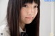 A young woman with long brown hair wearing a white shirt.